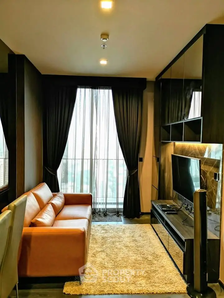 Luxurious living room with leather sofa and large TV, featuring floor-to-ceiling windows and elegant curtains.