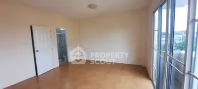 Spacious empty room with tiled flooring and large windows offering natural light.