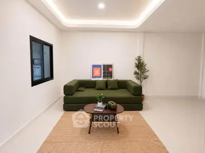 Modern living room with green sofa, minimalist decor, and cozy ambiance.