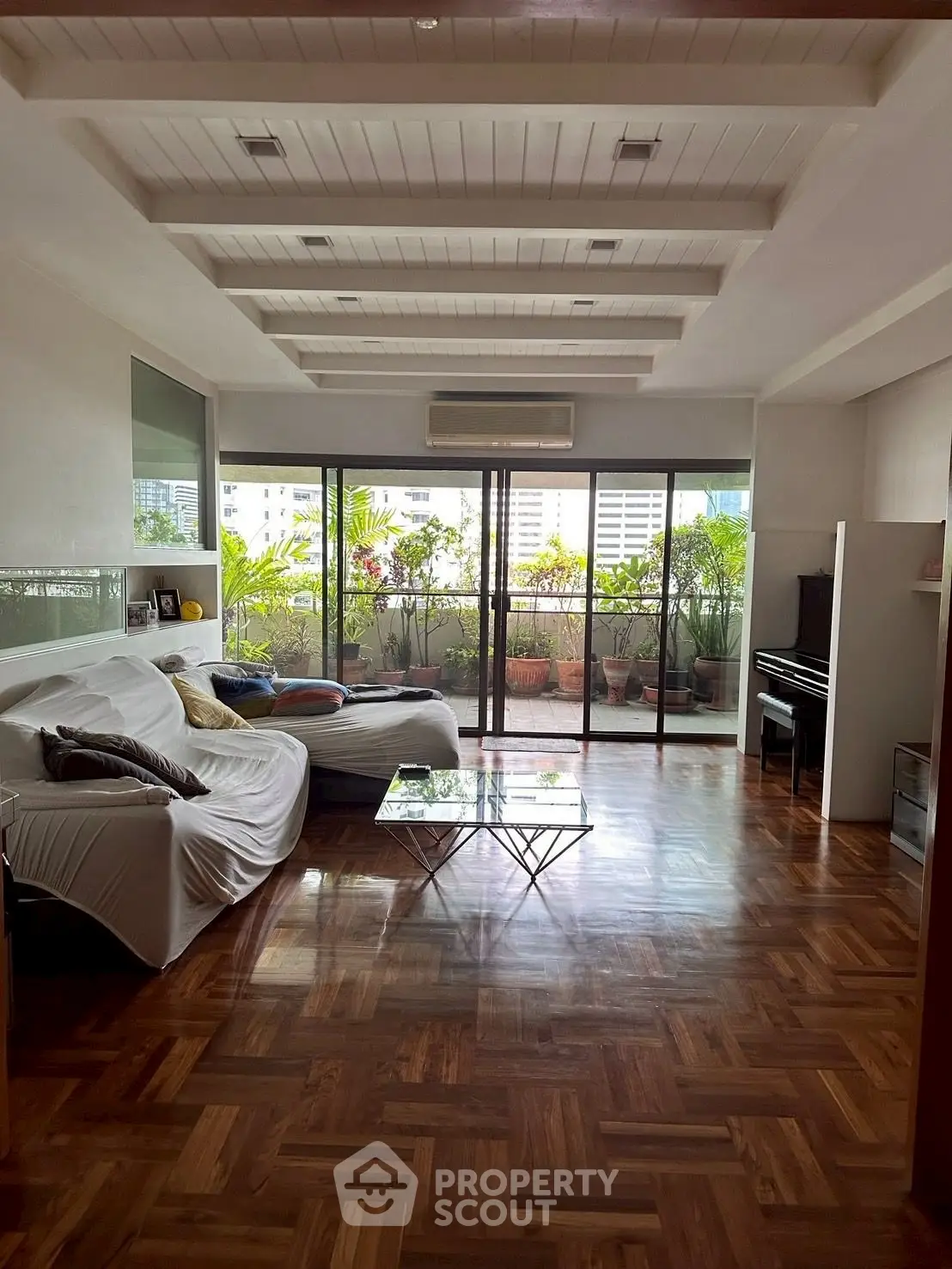 Spacious living room with elegant parquet flooring and large balcony view.