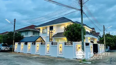 Stunning modern two-story house with elegant exterior lighting and spacious driveway.