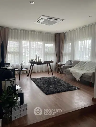 Spacious living room with modern decor and large windows offering natural light.