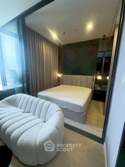 Modern bedroom with stylish sofa and floor-to-ceiling windows