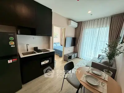 Modern open-plan living room and kitchen with stylish decor and natural light.