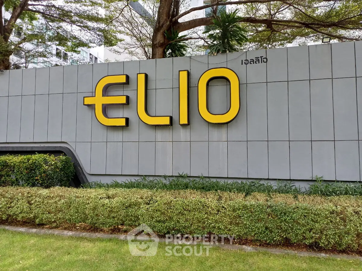 Modern building entrance with stylish signage and lush greenery