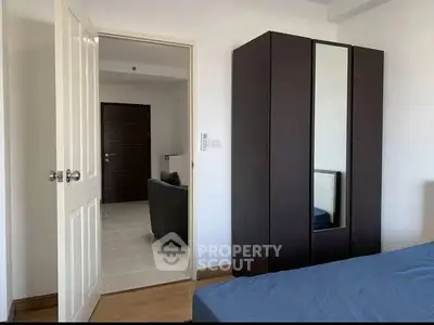 Modern bedroom with sleek wardrobe and open door to living area