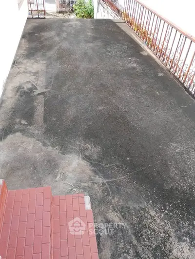 Spacious outdoor terrace with red brick steps and metal railing, ideal for gatherings.