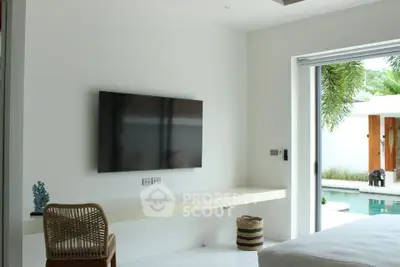 Modern living room with pool view and wall-mounted TV in luxury home