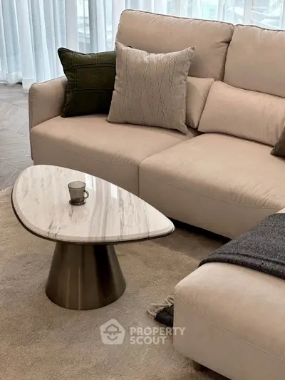 Elegant living room with modern beige sofa and stylish marble coffee table, perfect for cozy gatherings.