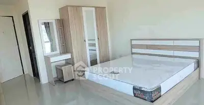 Spacious modern bedroom with stylish wooden furniture and ample natural light.