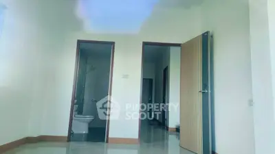 Spacious interior with modern bathroom and open doorway, ideal for customization.