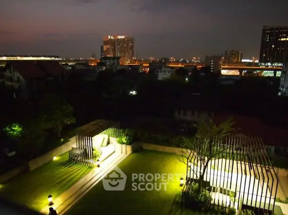 Stunning rooftop garden with city skyline view at night, perfect for relaxation and entertainment.