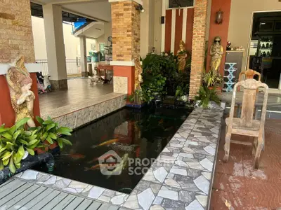 Charming home with decorative koi pond and rustic outdoor seating area.