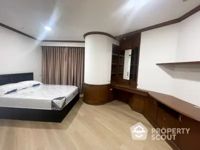 Spacious bedroom with elegant woodwork, ample storage, and modern flooring, ideal for luxurious living in a prime location.