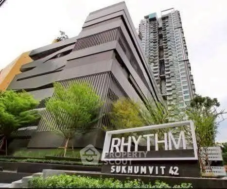 Modern high-rise building Rhythm Sukhumvit 42 with sleek architectural design and lush greenery.