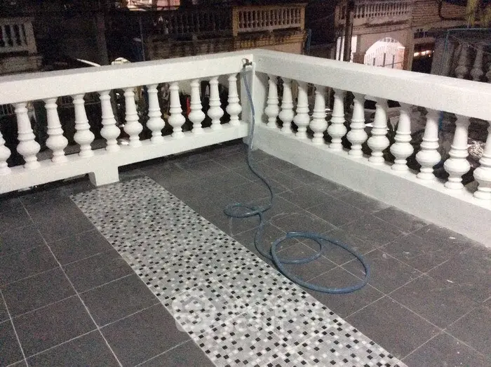 Spacious balcony with tiled flooring and decorative railing, perfect for outdoor relaxation.