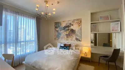 Elegant bedroom with large window and modern decor in a high-rise apartment.