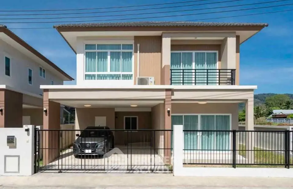 Modern two-story house with carport and gated entrance in a suburban neighborhood.