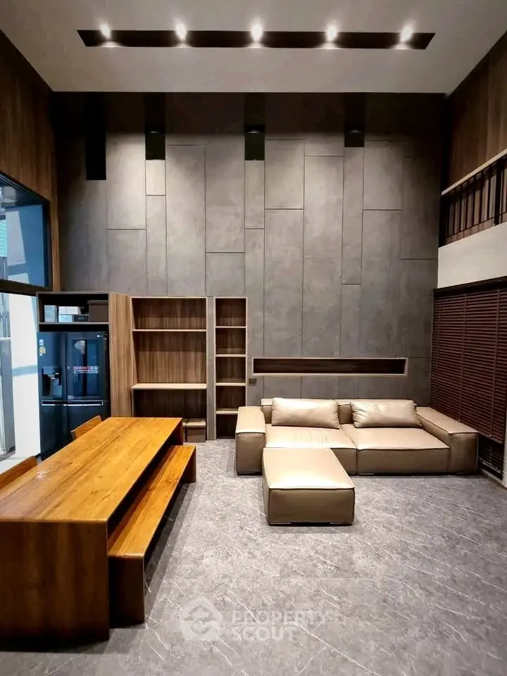 Modern living room with high ceilings, stylish furniture, and elegant wooden accents.