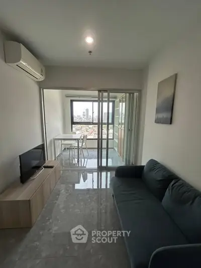 Modern living room with city view, featuring sleek furniture and large windows for natural light.