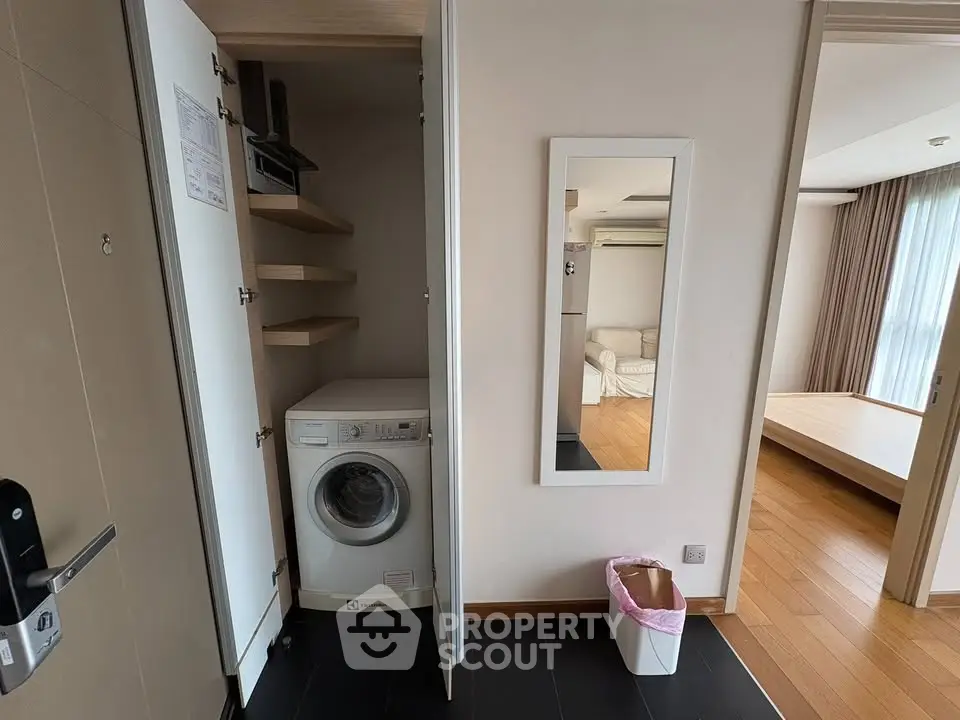 Modern apartment interior with washing machine in closet and stylish living area.