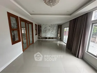 Spacious living room with elegant marble accent wall and large windows