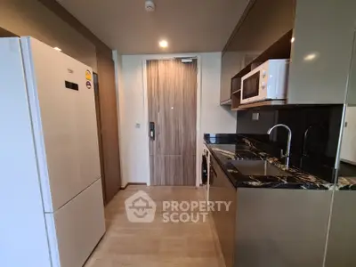 Modern kitchen with sleek appliances and stylish cabinetry in a contemporary apartment.