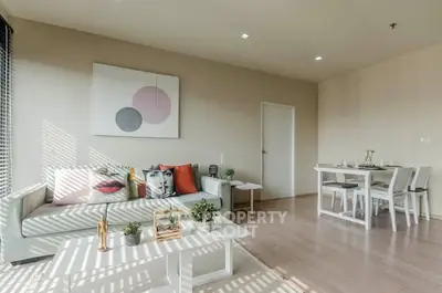 Modern living room with stylish decor and dining area, featuring natural light and contemporary furniture.