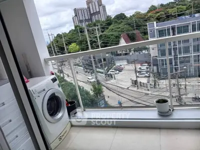 Modern balcony with washing machine and city view, perfect for urban living.