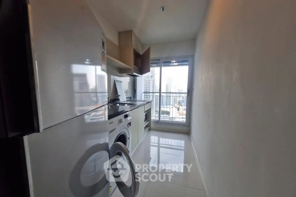 Modern kitchen with city view, featuring sleek appliances and glossy tiles.
