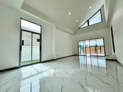 Spacious modern living room with high ceilings and large windows for natural light.