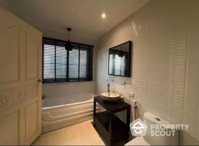 Elegant bathroom with modern fixtures and large window for natural light.