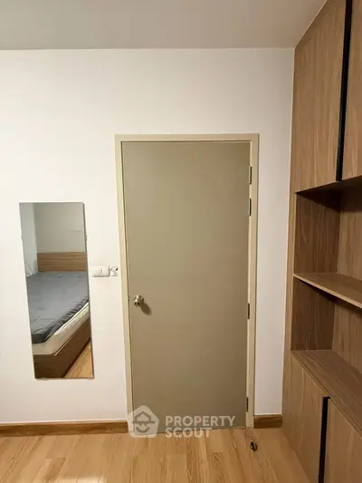 Modern bedroom with wooden flooring and built-in shelves