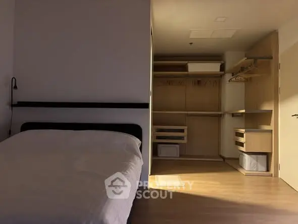 Modern bedroom with open walk-in closet and minimalist design.