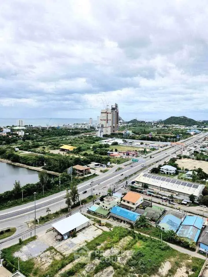 Stunning aerial view of coastal cityscape with lush greenery and modern buildings, perfect for real estate investment.