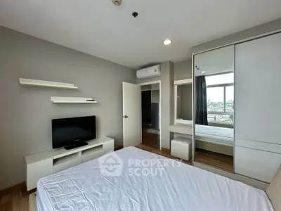 Modern bedroom with city view, featuring sleek furniture and ample natural light.