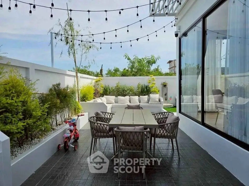 Charming outdoor patio with dining set and cozy seating area, perfect for entertaining.