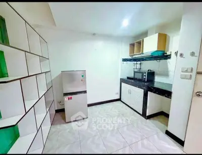 Modern kitchen with sleek appliances and stylish cabinetry in a contemporary apartment.