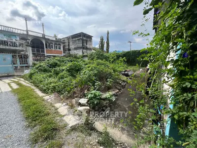 Vacant land plot with lush greenery and potential for development in urban area.