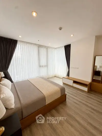 Spacious modern bedroom with large windows and elegant decor