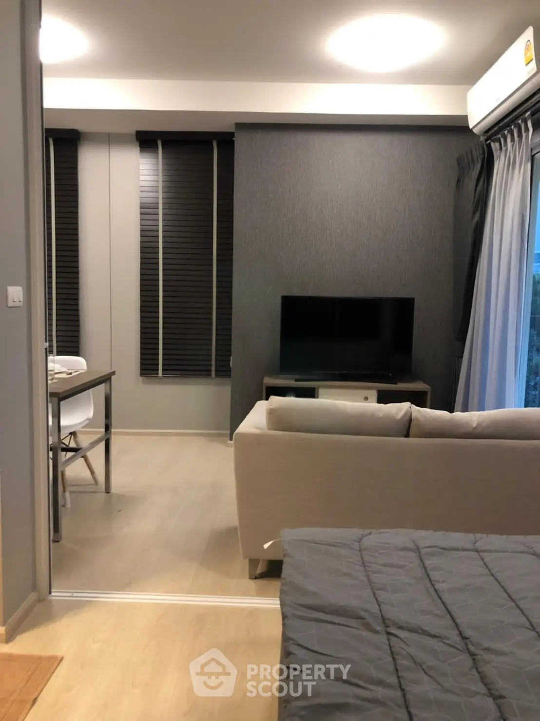 Modern living room with sleek design and cozy ambiance, featuring a comfortable sofa and flat-screen TV.