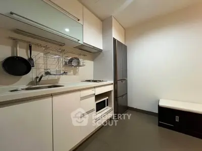 Modern kitchen with sleek cabinetry and stainless steel appliances in a compact layout.