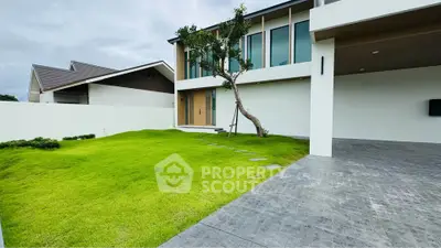 Modern minimalist home with lush green lawn and spacious driveway