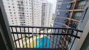 Stunning balcony view overlooking modern apartment complex and pool area.