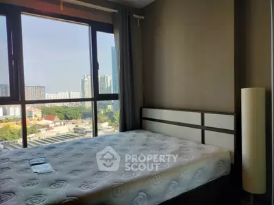 Spacious bedroom with city view and large window in modern apartment