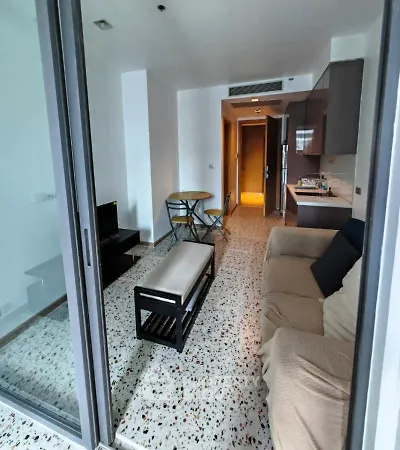 Modern living room with open kitchen and cozy seating area in a stylish apartment.