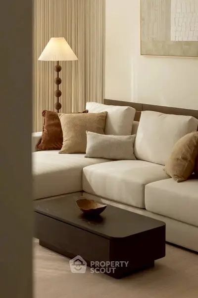Elegant living room with cozy beige sofa, stylish cushions, and modern lamp, perfect for relaxation.