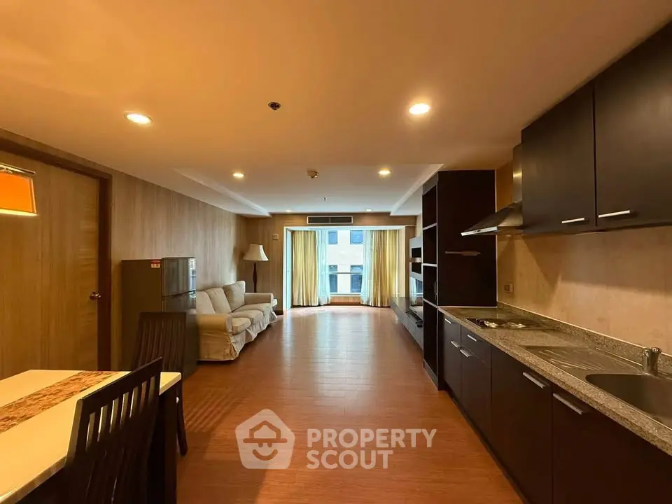 Spacious open-layout living room with modern kitchen and cozy seating area.