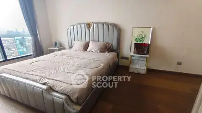 Luxurious bedroom with elegant bed and stunning city view from large window.