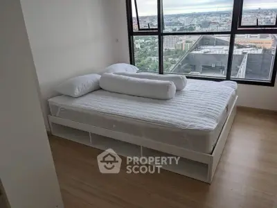 Spacious bedroom with stunning city view from large windows, featuring a modern bed and wooden flooring.